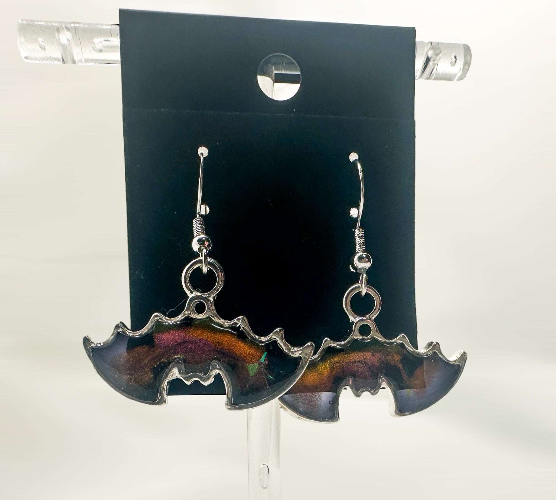 A pair of Hanging Bat Earrings handmade with resin and sunset colour shift with stars