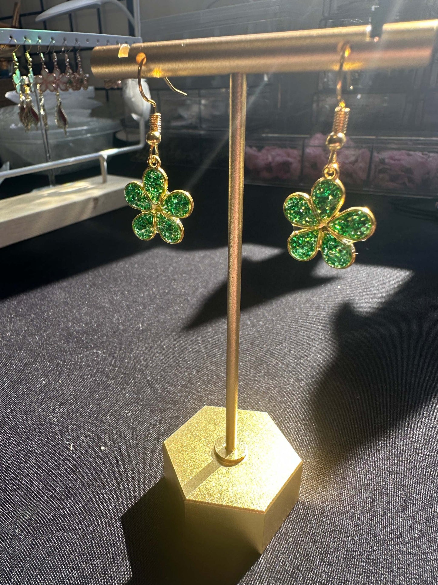 Pretty Flower shaped earrings with bright green glitter with a gold frame