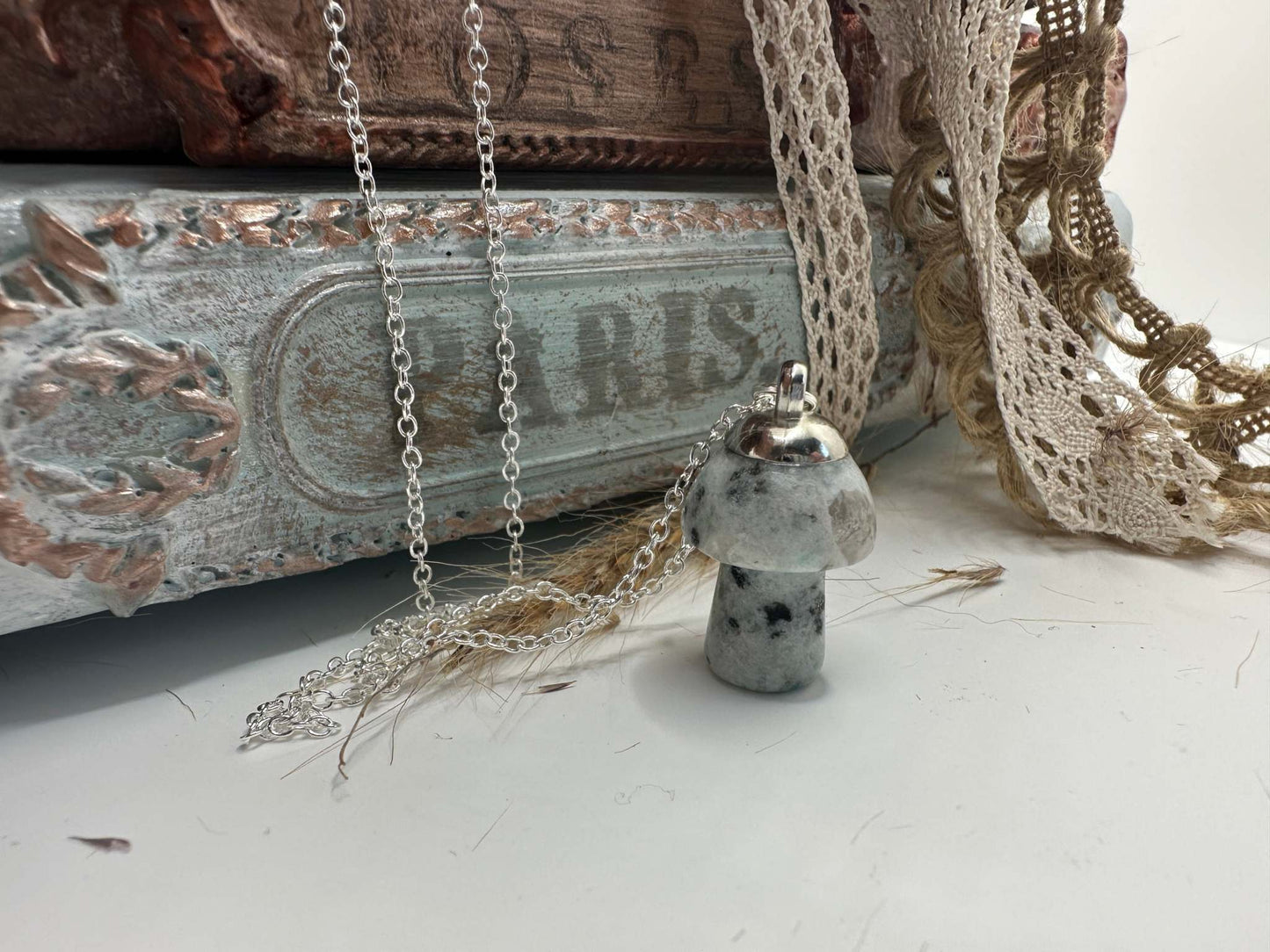 A Kiwi Jasper mushroom shaped gemstone necklace hangs from a silver chain