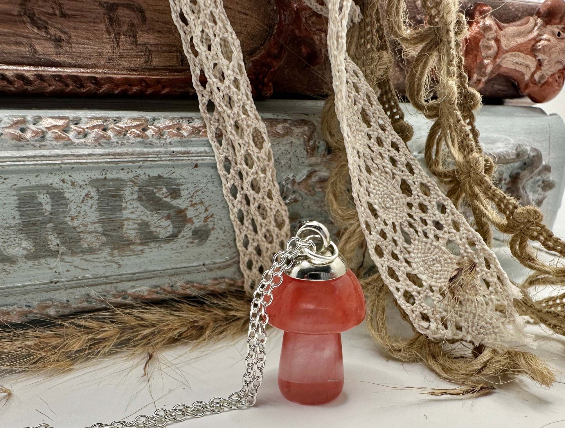 A Cherry Quartz mushroom shaped gem stone neckalce hanging from a silver chain