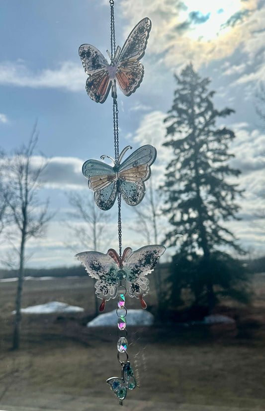 A Holographic Resin Butterfly Suncatcher that hangs from a pretty chain